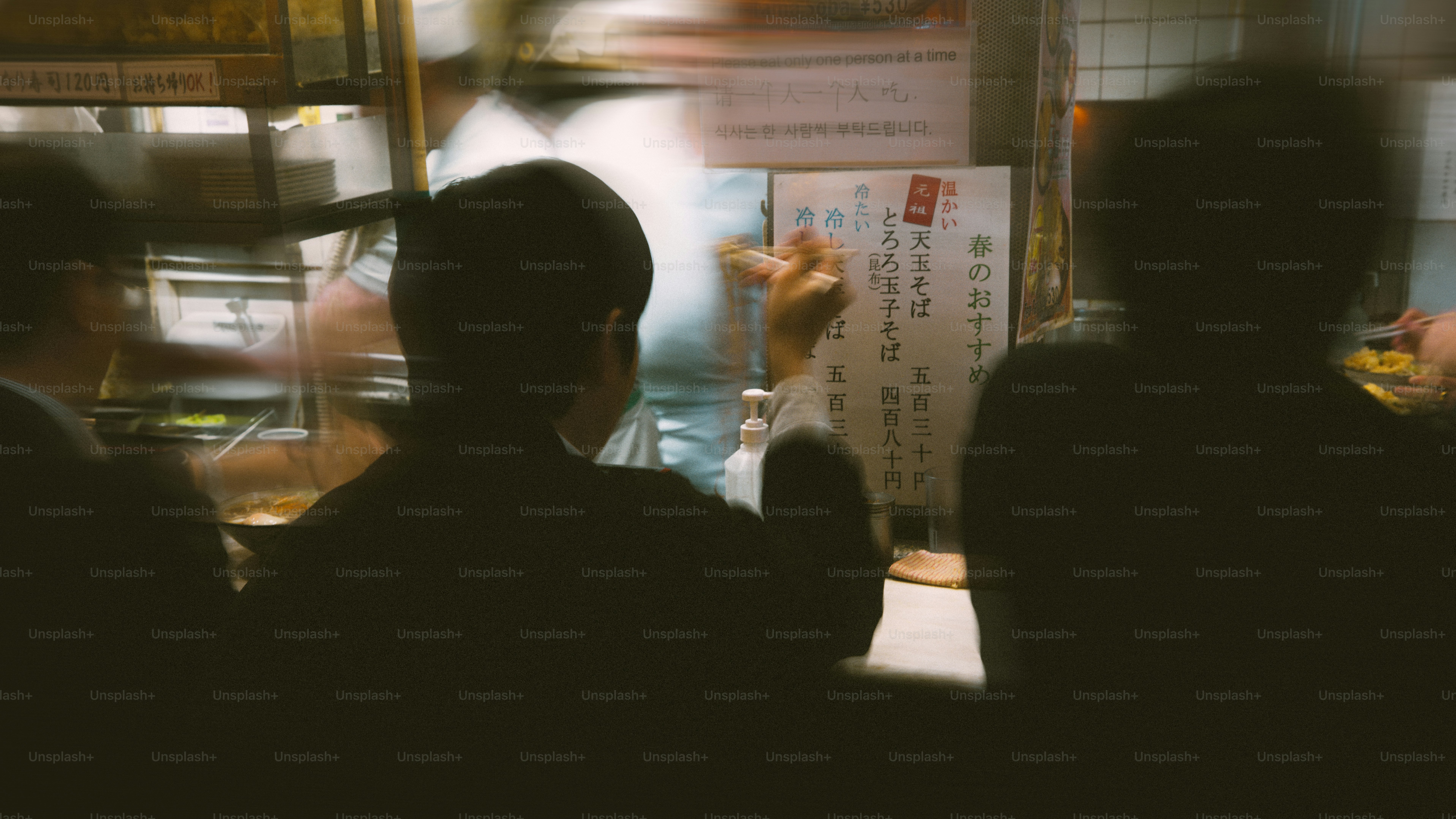 People at a counter, with a blurry background.